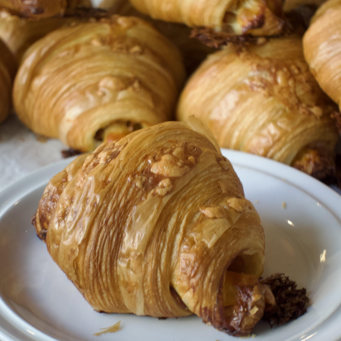 Side of Ham & Cheese Croissant on white plate